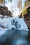 Frozen waterfall under snow cover in Wisla Czarne - Rodla Cascades in the Polish Beskydy Mountains, Poland. Wild nature and its