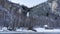 A frozen waterfall is visible in the gorge between the mountain slopes.