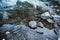 Frozen waters of green lake and stones