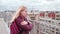 Frozen woman in leather jacket feel cold while standing on the roof in the wind