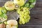 Fruit, Apple halves, kiwi, grape berries, spinach leaves, mint sprigs on a gray napkin on a brown wooden background top view