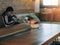 Fruit in a basket placed on a wooden table in a coffee shop and the background is blurred. A girl sitting on the phone