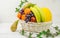 Fruit basket on white background with apple, pear melon grapes orange banana