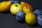 Fruit on a black background. Plums, pears and apples lie side by side.