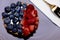 Fruit cheesecake with fork and napkin on a purple plate - blueberry and strawberry cream cake