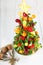 Fruit Christmas tree with different berries, fruits and mint