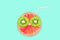 Fruit creative face with slices of grapefruit and kiwi, drinking straw on blue background, fruit juice concept