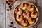 Fruit dessert tartlets with vanilla custard and fresh raspberries, blackberry, peach. Top view. Dark rustic style.