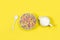 Fruit flavor colored cereals in a bowl and milk jug on a yellow background