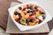 Fruit fresh homemade chopped salad for a diet breakfast and snack in a white bowl.