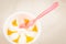 Fruit ice cream in a glass and spoon/fruit ice cream in glass and pink spoon on a white background, top view