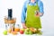 Fruit juice, pills and vitamin supplements. Woman holding glass full of pills standing next to juicer with loads of fresh fruit