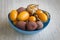 Fruit litchi, kumquat and inca berries in a blue bowl.