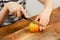 Fruit maestro: A young boy skillfully slices a ripe, yellow plum on a wooden background