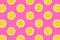 Fruit pattern of lemon slices on a pastel pink background