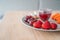 Fruit plate healthy fruits for breakfast on wood table. Strawberries, cranberry juice detox, grapes. Red color food