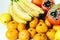 Fruit plate on white background. Mandarins, bananas, persimmons and lemons