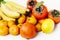 Fruit plate on white background. Mandarins, bananas, persimmons and lemons
