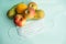 Fruit and protective mask on a mint background, fruit harvest, protection from coronavirus, fruit from China. Close-up