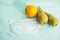 Fruit and protective mask on a mint background, fruit harvest, protection from coronavirus, fruit from China. Close-up, top view