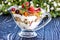 Fruit salad closeup with berries, yogurt and granola in a glass bow