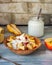 Fruit salad in deep bamboo plate with natural yoghurt and glass jar with yoghurt