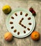 Fruit set like peach, pear, strawberries and orange. On the plate you can see nuts arranged in the form of a clock, implying that
