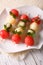 Fruit skewers of watermelon, kiwi and melon closeup. vertical to