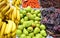 Fruit stand at the market with bananas pears grapes and cherries