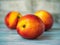 Fruit on the table. Three ripe yellow red nectarines