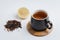 Fruit tea in a black mug on a bamboo support, lemon segment and dried tea isolated on white background