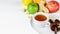 Fruit tea cup, dates on the white saucer. Tropical citrus fruits, ginger  and multivitamins pills on the white background. Autumn