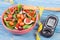 Fruit and vegetable salad and glucometer with tape measure, concept of diabetes, slimming and healthy nutrition