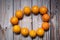 Fruit wooden letters surrounded by many orange fruits on a wooden table