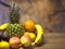 Fruit on wooden table, pineapple orange, pear, mandarin, banana, plum, apple and peach