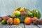 fruits of all kinds on wooden table and striped blue background. Peaches, yellow bananas, ripe watermelons, red apples