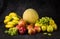 Fruits cabbage banana melon grape orange apples pear a dark background. health vegetarianism