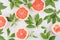 Fruits colorful fresh background - slice grapefruit and green leaves on white wood board.