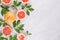 Fruits colorful fresh background - slice grapefruit and green leaves on white wood board.