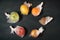 Fruits, each in individual plastic package on black background, concept of environment pollution contamination problem