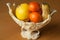 Fruits in an elegant plastic vase on the wooden table