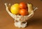 Fruits in an elegant plastic vase on the wooden table