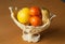 Fruits in an elegant plastic vase on the wooden table