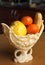 Fruits in an elegant plastic vase on the wooden table