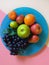 Fruits Grape Citrus mandarin Lime Green orange  grape  on Blue plate Pink and white Background concept Sweet fruits Still lif