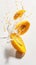 Fruits levitating in splashes. Ripe juicy mango pieces fly and fall in a splash of milk. Vertical image