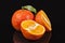 Fruits of mandarin orange ,whole and cut, on black background