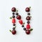 Fruits pattern of letter N english alphabet from natural ripe berries - black currant, cherries, raspberry, mint leaf