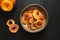 Fruits peach chips in bowl on black.