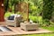 Fruits on table next to rattan armchair with pillows on wooden t